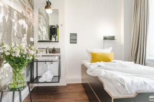 ein Schlafzimmer mit einem Bett und einer Vase aus Blumen in der Unterkunft Pyjama Park St. Pauli in Hamburg