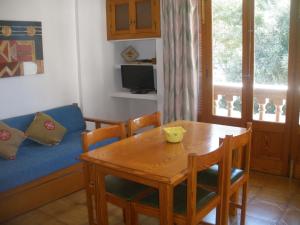 sala de estar con mesa y sofá en Apartamentos Can Jordi, en Cala Figuera