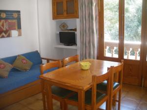 a living room with a table and a couch at Apartamentos Can Jordi in Cala Figuera