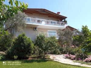 une maison avec un balcon sur le côté de celle-ci dans l'établissement BELLA-CAZA, à Nea Makri