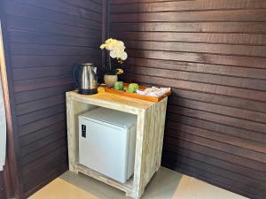 een kleine houten tafel met een koelkast in een kamer bij Villa Vilah in Nusa Penida
