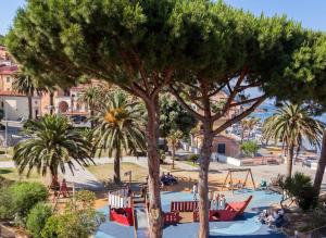 un parque con palmeras y un parque infantil en Hotel Rio Sul Mare, en Rio Marina