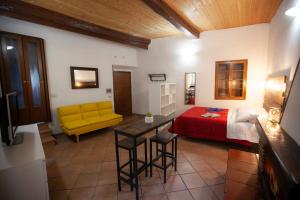 1 dormitorio con cama y sofá amarillo en Casa Nena en Nepi