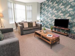 a living room with a couch and a tv at Apartment 2 Blackpool Sleepover in Blackpool