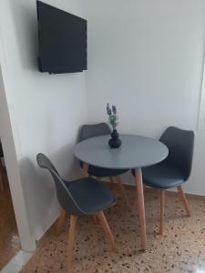 a table and two chairs and a tv in a room at Flora Rooms & Apartments in Naousa
