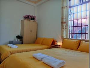 a bedroom with two beds and a window at Guesthouse Big Lucky in Da Lat