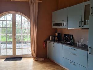 a kitchen with white cabinets and a large window at BUND-Ferienwohnung in Lenzen