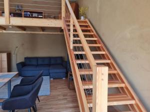 BUND-Ferienwohnung في Lenzen: درج يؤدي إلى غرفة المعيشة مع أريكة زرقاء