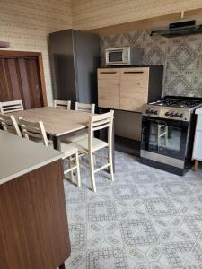 a kitchen with a table and chairs and a stove at Casa Adélona in Ofena