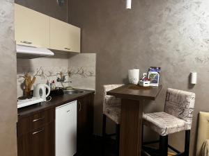 a kitchen with a sink and a counter with chairs at Apartman Studio DIAMOND in Subotica