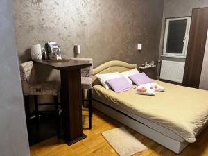 - une petite chambre avec un lit et une table dans l'établissement Apartman Studio DIAMOND, à Subotica