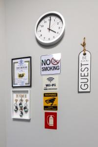 a wall with a clock and signs on it at E-home Apartments in Varna City