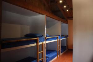 um quarto com 3 beliches com lençóis azuis em Albergue La Casa del Camino em Valverde de la Virgen