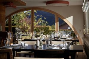 un comedor con una mesa con copas de vino en Hotel Pazzola, en Disentis