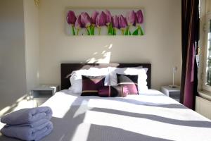 a bedroom with a bed with purple tulips on the wall at Eelhouse private studio in Amsterdam