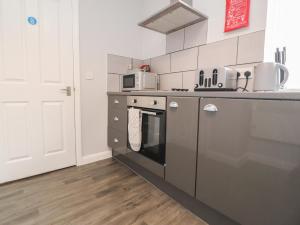 a kitchen with a stove and a microwave at Apartment 4 Blackpool Sleepover in Blackpool