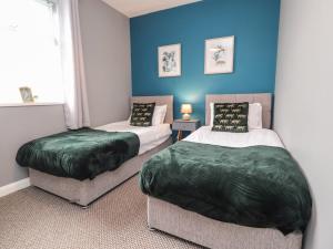 two beds in a room with blue walls at Apartment 4 Blackpool Sleepover in Blackpool