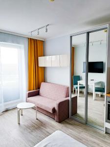 a living room with a pink couch and a table at Hotel Sympozjum & SPA in Krakow