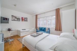 een slaapkamer met een groot wit bed en een bureau bij Private Studio - Wardour Street - Berwick Street in Londen