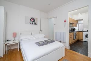 een witte slaapkamer met een bed en een keuken bij Private Studio - Wardour Street - Berwick Street in Londen