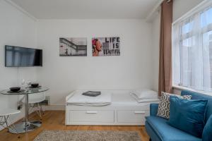een woonkamer met een bank en een tafel bij Private Studio - Wardour Street - Berwick Street in Londen