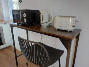 uma mesa com um micro-ondas e um aparelho em Ritta´s House - Covilhã na Covilhã
