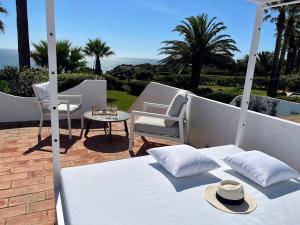 1 cama blanca, 1 silla y 1 mesa en Casa Eureca, en Carvoeiro