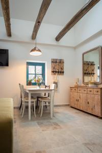 a dining room with a table and chairs and a mirror at Stüble Loft in Somogyhárságy