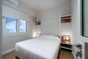 a bedroom with a white bed and two windows at Hidden Athens in Athens