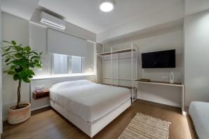 a bedroom with a white bed and a tv at Hidden Athens in Athens