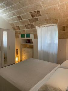 Macchia di MonteにあるIl Vecchio Carrubo - Villa con piscina a sfioroの石造りの天井のベッドルーム1室(ベッド1台付)