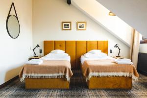 2 łóżka w pokoju ze schodami w obiekcie Dwór w Zabużu w mieście Zabuże