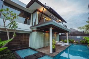 eine Villa mit Swimmingpool und ein Haus in der Unterkunft Javana Royal Villas in Seminyak