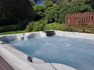 een hot tub in een tuin met blauw water bij Robin Hood Farm B&B in Baslow