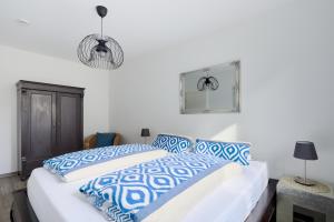 Schlafzimmer mit einem Bett mit blauen und weißen Kissen in der Unterkunft Ferienwohnung Hafeneck Moba-Travel in Lübeck