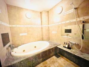 y baño con bañera y lavamanos. en 嵐 Hotel Arashi 心斎橋店 en Osaka