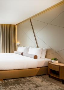una camera da letto con un grande letto con cuscini bianchi di Hotel Klassik Berlin a Berlino