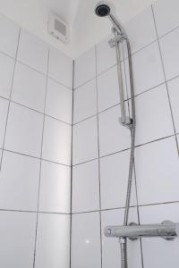een douche in een badkamer met witte tegels bij Studio Eelhouse in Amsterdam +18 foto's