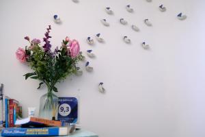 een vaas met bloemen op een tafel met vlinders bij Studio Eelhouse in Amsterdam