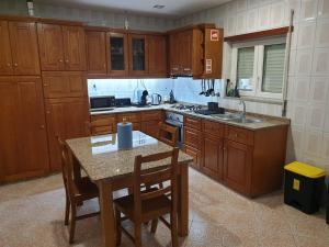 una cocina con armarios de madera y una mesa con sillas. en Cantinho dos Montes, en Vila Real