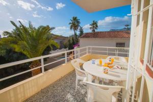 a balcony with a table and chairs and palm trees at Villa Corina - Plusholidays in Calpe