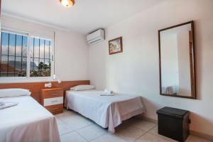 a hotel room with two beds and a mirror at Villa Corina - Plusholidays in Ifach +23 photos