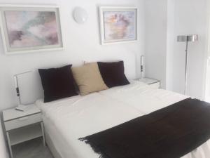 ein Schlafzimmer mit einem großen weißen Bett mit zwei Lampen in der Unterkunft Near beach 2-Bed Apartment in Centrum Fuengirola in Fuengirola