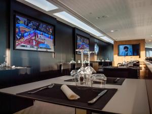 a dining room with a table and two televisions on the wall at Rafa Nadal Residence in Manacor