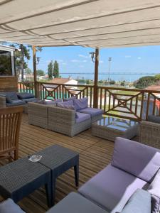une terrasse couverte avec des canapés et des tables. dans l'établissement Hôtel Mer et Forêt, à Saint-Trojan-les-Bains