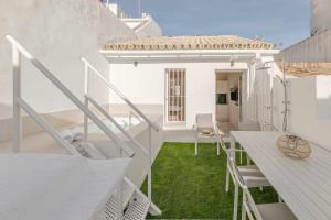 a balcony of a white house with a table and chairs at ISG Apartments Cuna in Seville