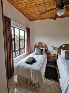 1 dormitorio con 2 camas y ventana en Lake St Lucia Villas, en St Lucia