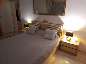 ein Schlafzimmer mit einem Bett, zwei Lampen und einem Spiegel in der Unterkunft Apartment River in Bacău