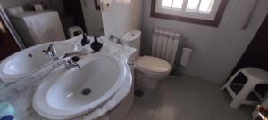 a white bathroom with a sink and a toilet at RINCÓN DEL MIÑO in Tomiño +18 photos