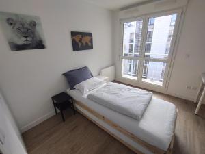 ein kleines Schlafzimmer mit einem Bett und einem Fenster in der Unterkunft 10 mins walk to metro,La Défense, renovated in Courbevoie